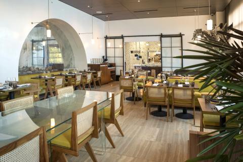 Elegant restaurant interior with glass tabletops and green chairs