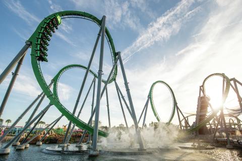 The Incredible Hulk Coaster at Universal’s Islands of Adventure launches riders through high-speed loops above the water under a bright Florida sky.