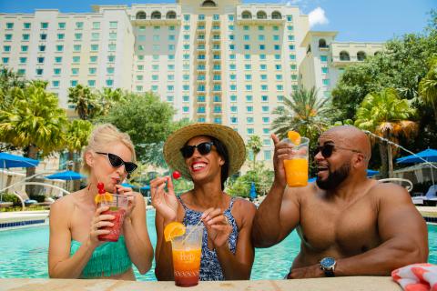 3 Friends poolside drinking tropical drinks at the Omni Orlando Resort at ChampionsGate