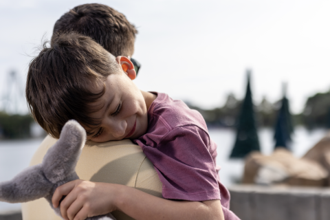 Dad holds young, sleeping son at SeaWorld Orlando.