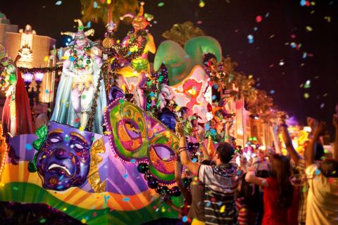 Mardi Gras float with bright colors and lights roll by on the streets at Universal Orlando Resort. 