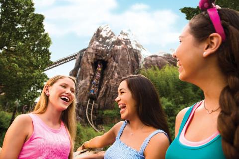 Friends laughing in front of Expedition Everest roller coaster at Disney's Animal Kingdom