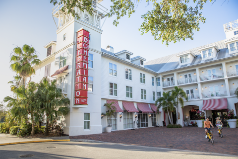 Exterior of white building with red awnings called Inn at Celebration.