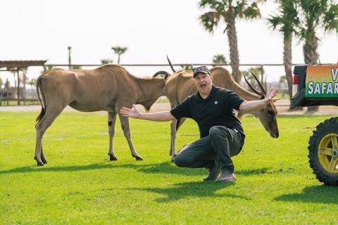 Jeff Musial kneels in front of two horned antelope at the Wild Florida Drive-Thru Safari Park.