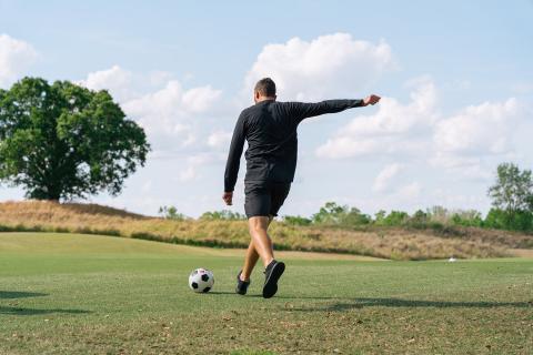 Luke Boden kicks a soccer ball on the footgolf course at Reunion Resort.