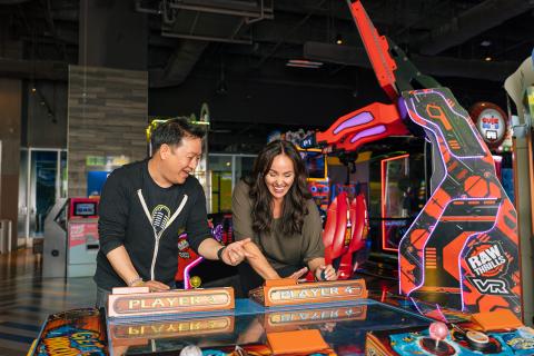 Ming Chen and Jen Bonner play an arcade game at Main Event Entertainment.
