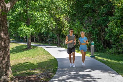 Man and woman walk around the lush trail at Celebration Town Center.