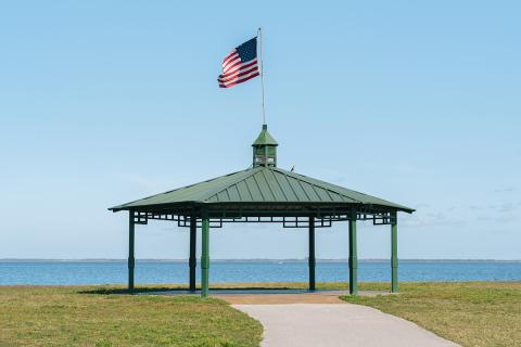 Pavilion with an American flag on top near the water in St. Cloud. 