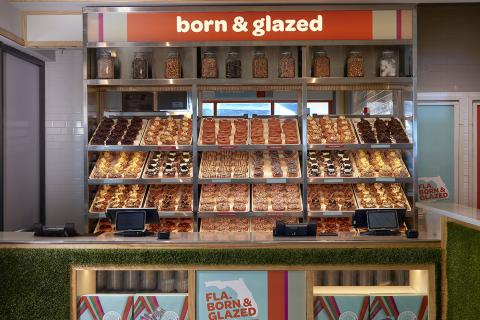 A close up of the doughnut display has an orange sign above it that reads, "born and glazed."