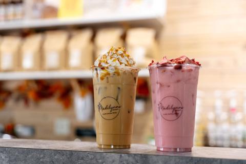 A coffee with whipped cream and caramel and a Pink Drink made from fresh strawberries are displayed at the counter at Madilynns Craft Coffee Shop.