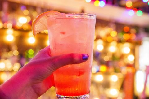 A glass of Kissimmee Lemonade from local bar Breeze Kissimmee, featuring a citrus garnish against a lively bar backdrop.