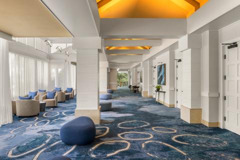 The pre-function area of Delta Hotels by Marriott Orlando Celebration are bright and wide open with comfortable seating and large windows with views to the outside.