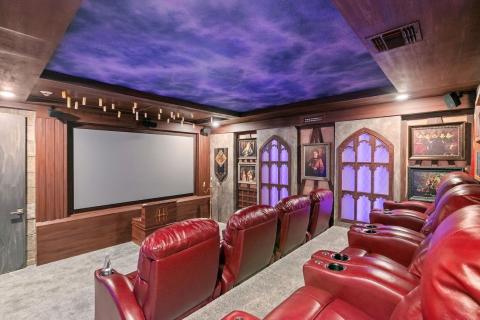 The movie theater within Grand Casita Cantina is decorated like a Spanish-style home with arched faux windows and a ceiling mimicking a cloudy evening sky.