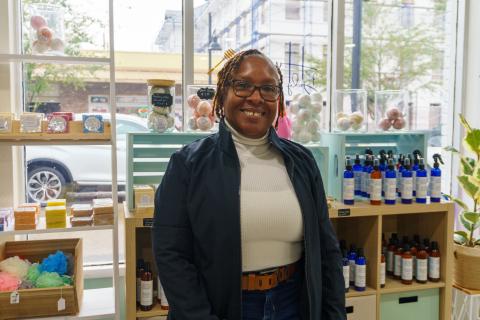 Sherida “Hunnie” Emans, owner of Hunnies Body Butter in downtown St. Cloud, Florida, standing proudly by a display of natural soaps, bath bombs and liquid body butters.
