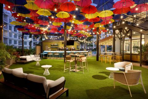 The Wilson offers indoor and outdoor seating. Outdoor seating is under a covered patio with warm string lights, decorative umbrellas, cozy benches and chairs.
