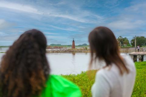 Two women admire the view of a small lighthouse across the lake at Lakefront Park in Downtown Kissimmee.