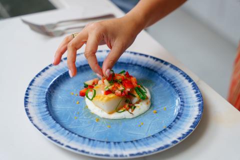 Close-up of a beautifully plated dish prepared by Maryam Ishtiaq in a Kissimmee vacation home kitchen, featuring vibrant strawberries and freshly picked onions from Mick Farms.