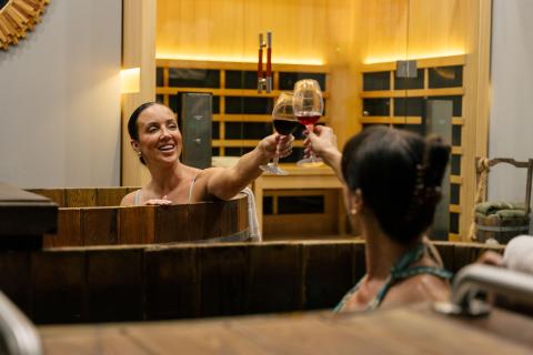 Chelsea Green and host Jen Bonner clink glasses while soaking in side-by-side beer baths at Beer Spa in Kissimmee.