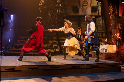 Jen Bonner practices swordplay with a pirate performer onstage at Pirates Dinner Adventure in Kissimmee.