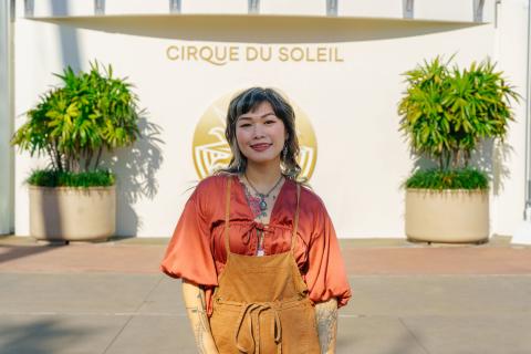 Yvette Young poses outside the Cirque du Soleil tent at Disney Springs®, with the iconic white structure behind her.