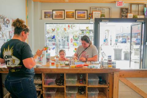 Mother and young daughter working on a glass mosaic project together inside The Stained Glass Lady art studio in Downtown St. Cloud.