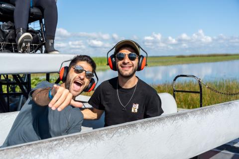Los Gemelos sonríen y señalan a la cámara durante un paseo en airboat en Boggy Creek Airboat Adventures.
