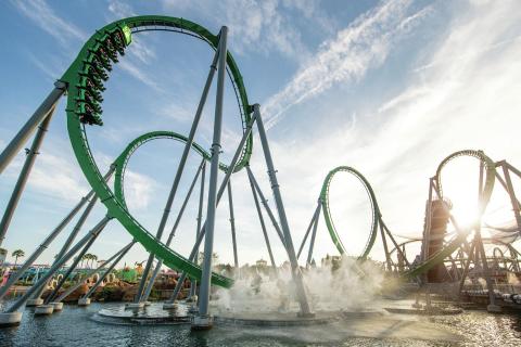 The Incredible Hulk Coaster at Universal’s Islands of Adventure launches riders through high-speed loops above the water under a bright Florida sky.