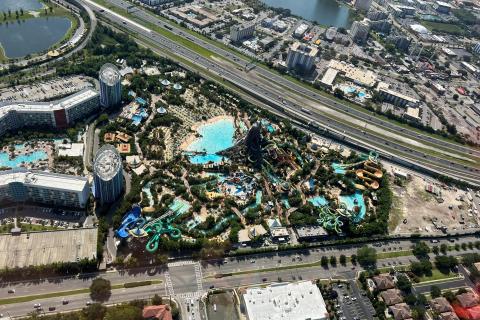 Aerial view of Universal’s Volcano Bay water theme park, showcasing the Krakatau volcano, winding slides, sandy beaches, pools, and surrounding resort buildings.