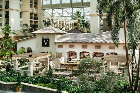 Villa de Flora at Gaylord Palms, featuring an elegant Mediterranean-inspired dining space surrounded by lush indoor gardens and string lights.