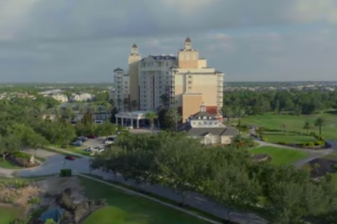 An aerial shot of Reunion Resort & Golf Club, showing an expansive property with golf courses, homes, and a multi-story building that is the clubhouse.