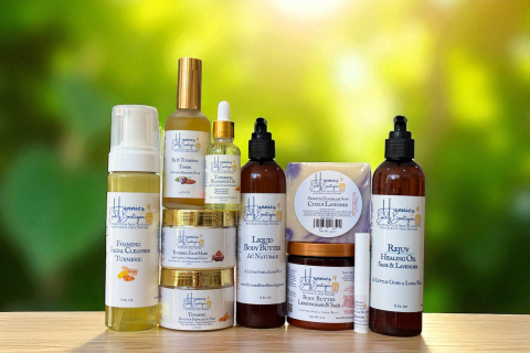 Collection of natural skincare products from Hunnies Body Boutique, including cleansers, toners, body butters, soaps, and healing oils displayed on a wooden surface.