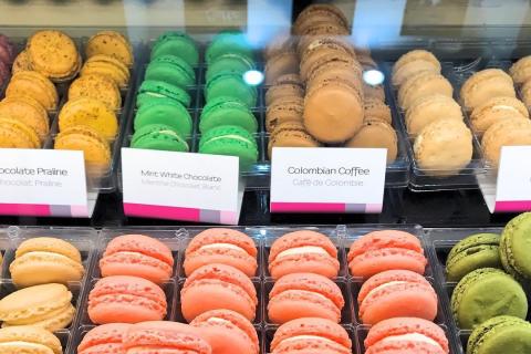 Close-up of colorful macarons displayed in neat rows at Le Macaron in Kissimmee, featuring flavors like mint white chocolate, Colombian coffee, and chocolate praline.