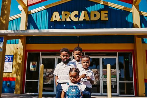 Four children stand in front of the entrance to Fun Spot Kissimmee.