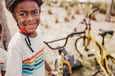 A boy stands with a yellow bike in Celebration, Florida.