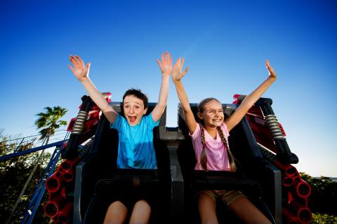Two young kids riding a roller coaster in Kissimmee