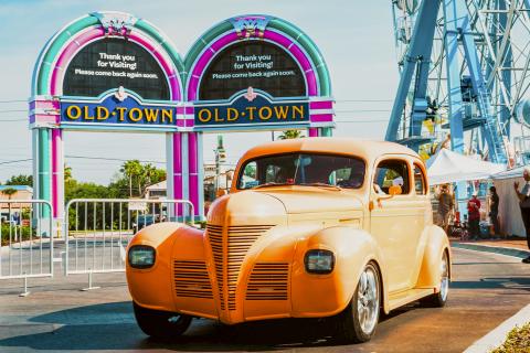 A classic car sits outside the iconic Old Town sign.
