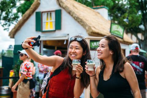 Women posing for a selfie with glasses of Bailey's Irish Cream in their hand