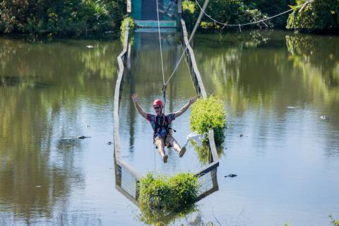 Visitor ziplining over an alligator pond at Gatorland in Orlando, Florida, located near Kissimmee, showcasing one of Central Florida’s most thrilling accessible adventures.