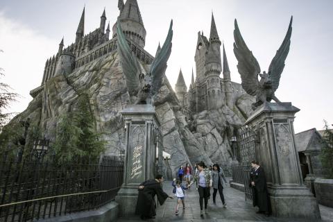 Visitors leave Hogwarts Castle at the Wizarding World of Harry Potter and are greeted by cast members in robes.