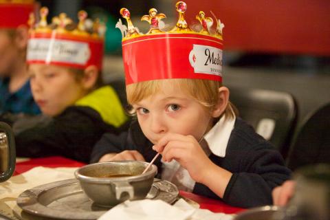 Boy wearing crown enjoying dinner and tournament at Medieval Times