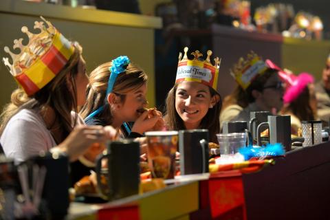 Guests wearing crowns enjoy dinner and live entertainment at Medieval Times Dinner & Tournament in Kissimmee, Florida, where medieval knights and royal festivities create an unforgettable dining experience.
