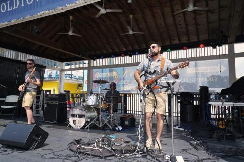 Two musicians perform on a stage in Old Town Kissimmee