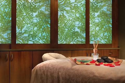 Peaceful spa treatment room with a massage table, rose petals, hot stones, and aromatherapy oils at Relâche Spa.