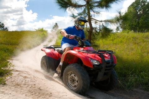 Rider on a red ATV with Revolution Adventures