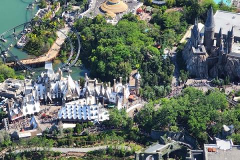 Aerial view of Universal Orlando’s The Wizarding World of Harry Potter, including Hogsmeade village, Hogwarts Castle, and surrounding roller coasters.