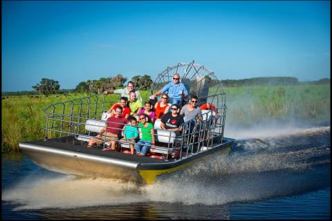 A group of people ride on an airboat through the marsh in Kissimmee