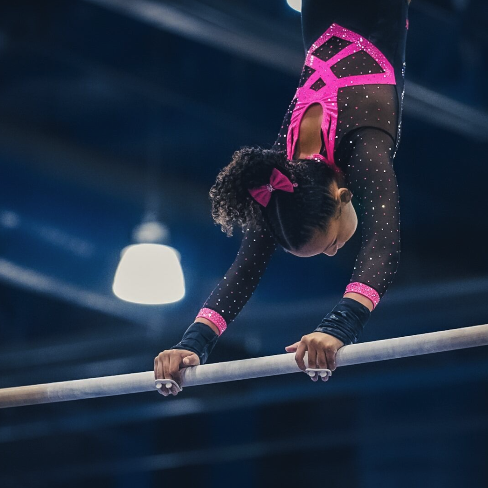 A gymnast swings on the high bar. 