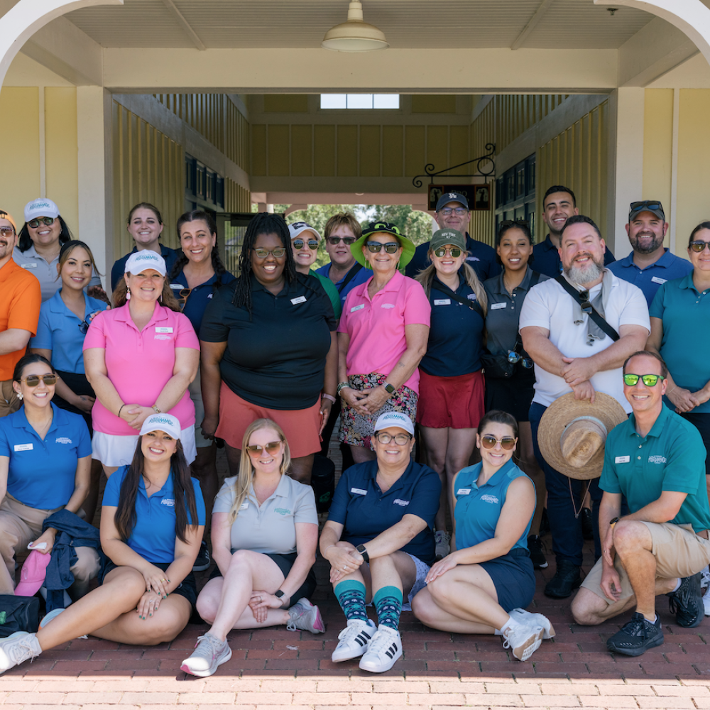Group photo of Experience Kissimmee team members smiling and posing together at the Kissimmee Golf Classic Event