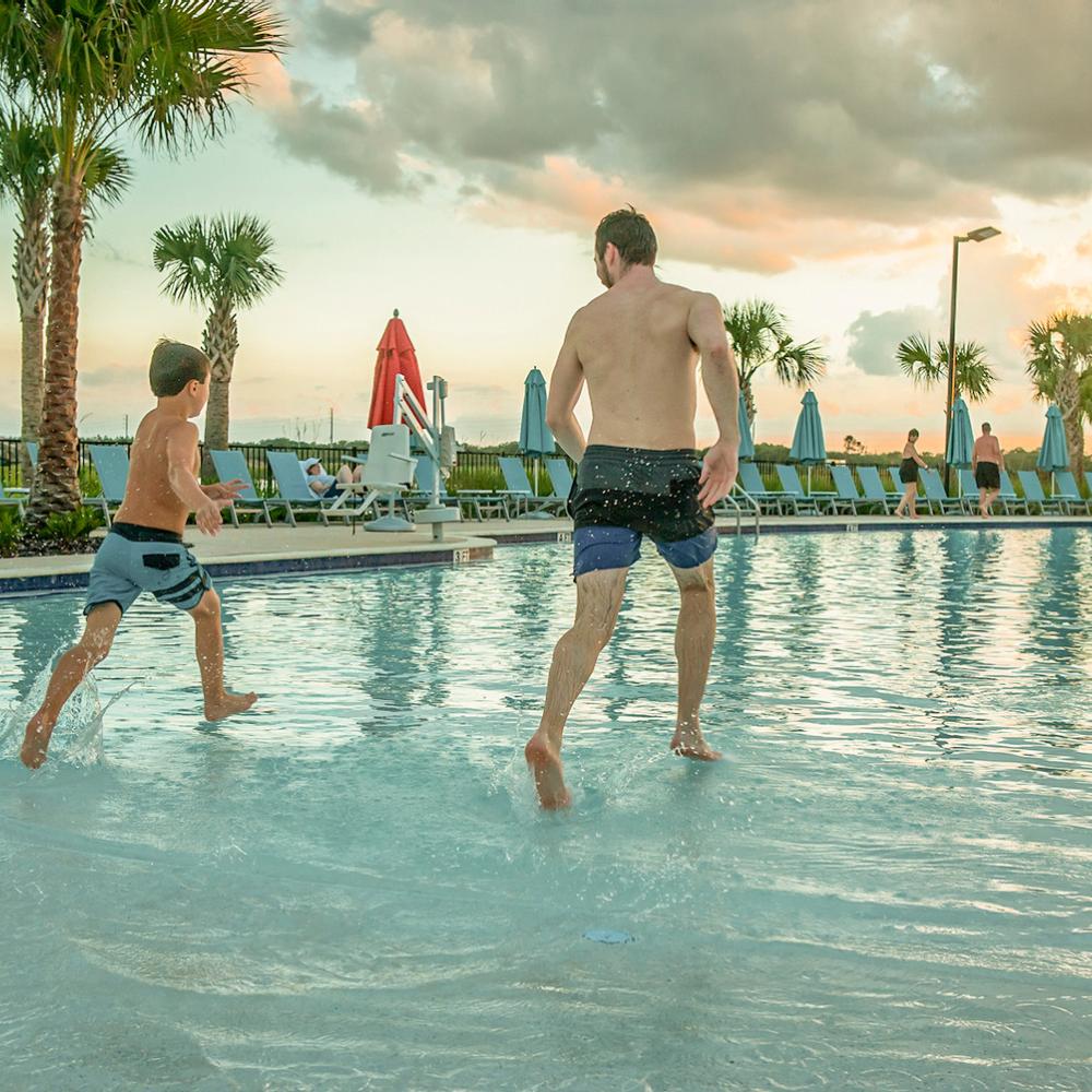 A man and child run into the pool