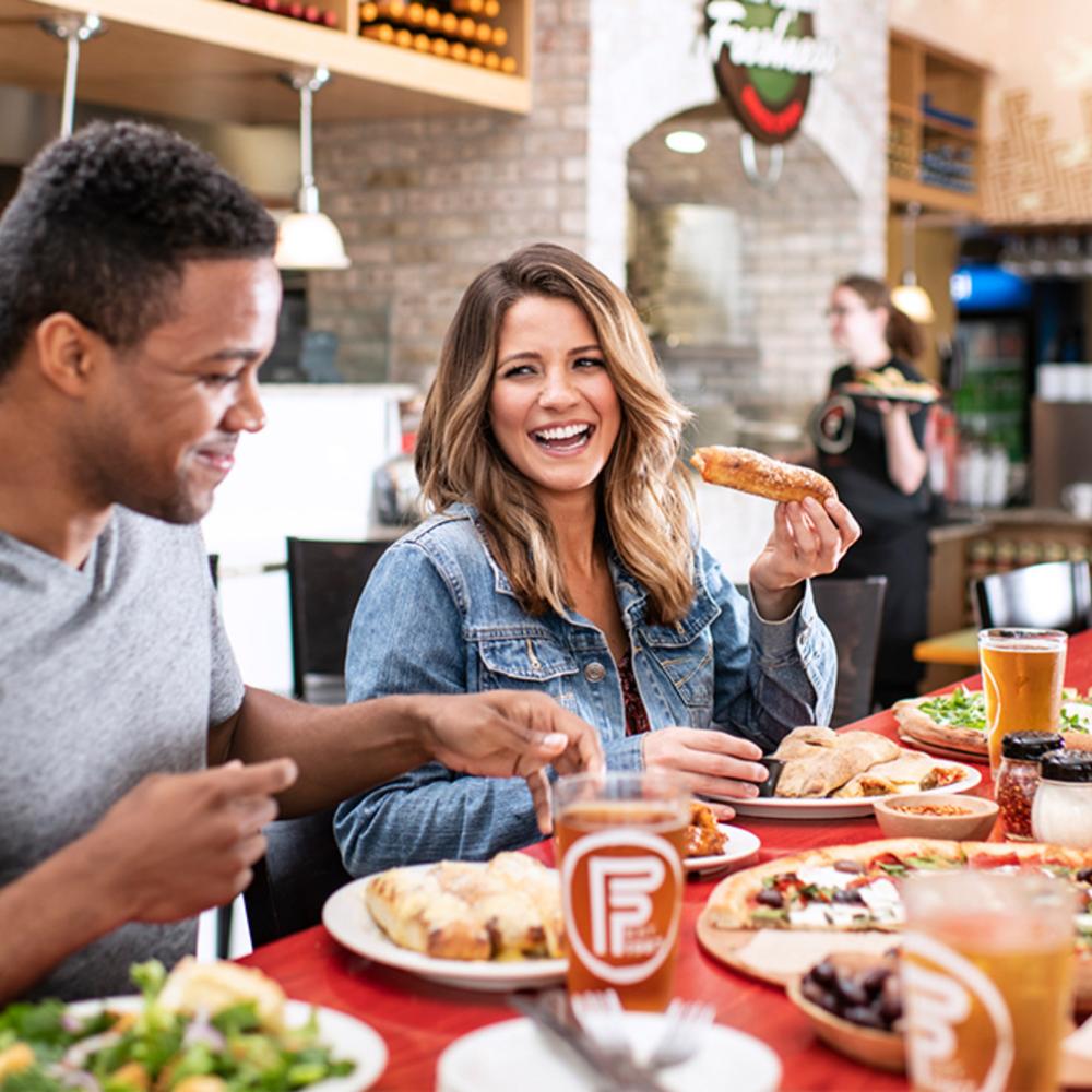 A man and a woman eating in a restaurant 